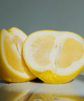 Freshly sliced lemon halves with juicy segments on reflective surface