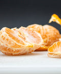 Fresh peeled citrus segments on white surface, vibrant orange slices ready to enjoy
