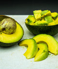 Fresh California avocado halves, slices, and diced pieces on a cutting board