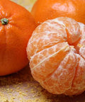 Fresh California citrus oranges, one peeled, showcasing juicy segments perfect for gift boxes